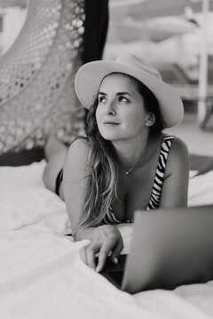 Woman working on laptop on vacation, on the beach, freelancer.