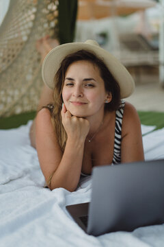 Woman working on laptop on vacation, on the beach, freelancer.