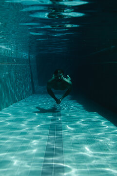 Man swimmer in the pool underwater.