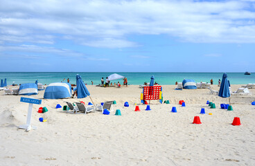 Kids area of beach with sun loungers and umbrellas at South Pointe on winter sunny day. Miami Beach, Florida