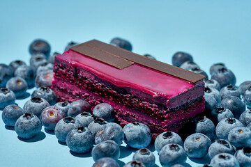 Blueberry sponge cake with a composition with berries on a blue background. Food pattern