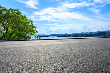 Asphalt road and green tree with mountain background