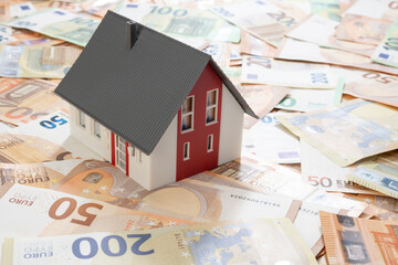 Real estate loan concept; House on European Union currency over white background