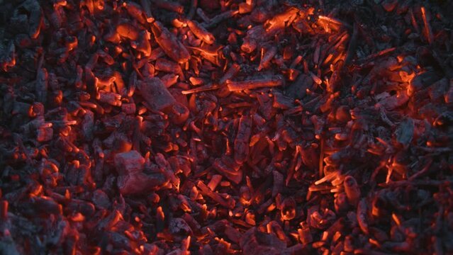 Fireplace close-up. Bright flames of burning fire, coals and ashes background. High quality 4k footage