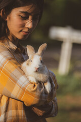 Obraz premium relationships of cheerful rabbit and happy young human girl, Asian woman holding and carrying cute rabbit with tenderness and love. Friendship with cute easter bunny. Happy of Easter's Day