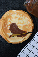 Spread sweet paste on a crepe or blini. Snack with nut, chocolate, sweet paste for breakfast