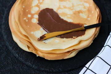 Spread sweet paste on a crepe or blini. Snack with nut, chocolate, sweet paste for breakfast