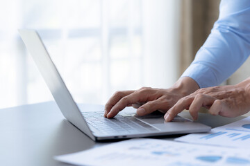 Businessman sitting using laptop computer on table in office.