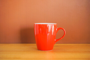 Red cup of coffee on wooden table