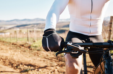 Man, hands and bicycle in countryside, nature and training in sunshine for triathlon, sports and cardio competition. Cyclist gloves, bike and outdoor fitness for cycling marathon, exercise and race