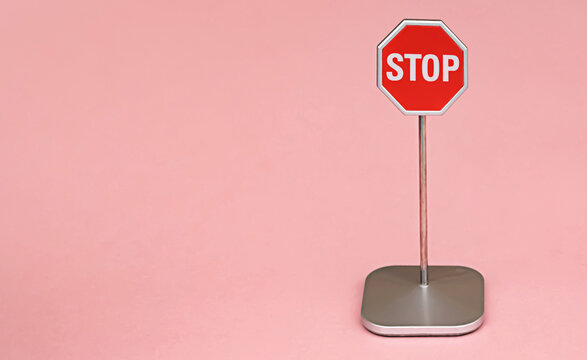 Red stop sign, traffic warning octagon pink background with copy space for your text or object
concept symbol
detention