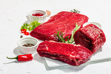 Set of various steaks with spices and herbs. Eye round, flank and striploin steaks