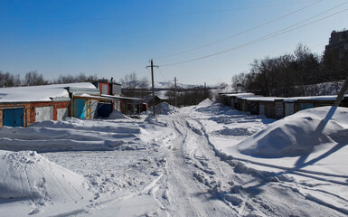 Garage cooperative. Cooperative buildings lines for vehicle parking. An example of a collective household. Spring. White snow and Blue sky. Ust-Kamenogorsk (kazakhstan)