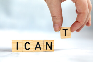 Change the word I can't to read I can concept for self belief, positive attitude and motivation, Hand removing the can't text wooden cubes background texture