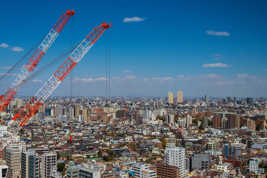 Construction industry and development. Crane at work among in Tokyo endless suburbs