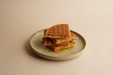 Delicious Belgian waffles with honey in plate