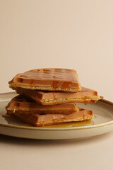 Delicious Belgian waffles with honey in plate