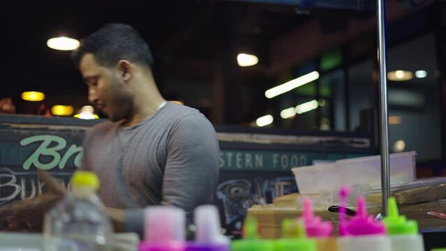 Street cook preparing a thai rotee dough in a street market