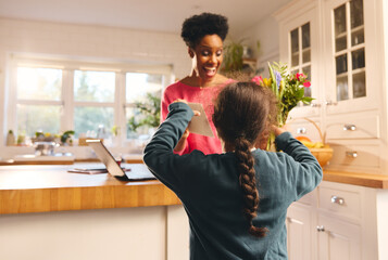 Boy giving mother bouquet and card on Mother's Day or Birthday