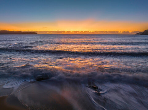 Aerial sunrise seascape with clear skies and low cloud bank