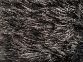 Long gray fake fur texture cover. Synthetic fiber soft faux fur macro fabric photo. Monochrome fluffy furry surface for digital paper design Winter clothes coat backdrop Textile mat close-up wallpaper