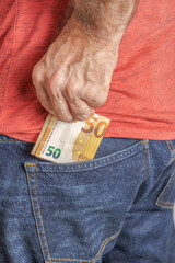 man holding euro banknotes in his pocket