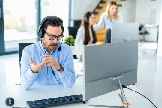 Dedicated male customer service representative communicating with customer trying to provide appropriate solutions for client issues at call center.