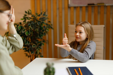 A mute teacher and a deaf child communicate in sign language.