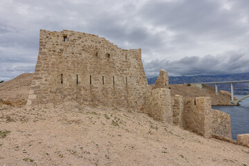 In front of the ruins of Fortress Fortica with the Pag Bridge in the background