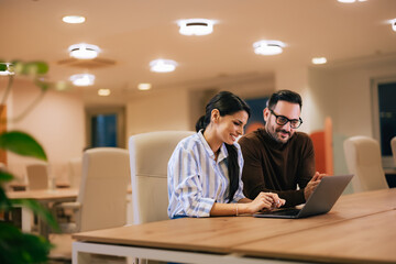Business partners working together, using a laptop at the office.