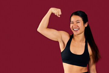 Fototapeta na wymiar Portrait of an Asian sporty woman showing her arm muscle, dressed in a sports set.