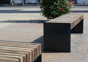 Wooden benches in city street on sunny day
