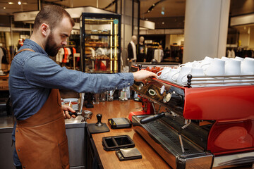 A man and a girl make coffee at a coffee machine in a coffee shop