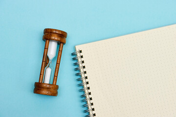 Sand running through the bulbs of an hourglass measuring the passing time in a countdown to a...