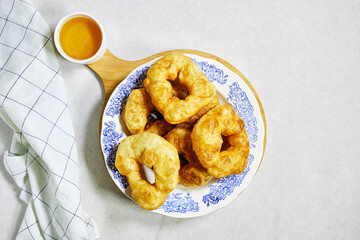 traditional Algerian fried baked donuts or pancake named Sfenj with honey bowl