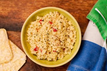 Rice bread and couscous tomato and spice salad. Tabbouleh salad. Wooden background. Food simple concept.