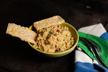 Rice bread and tomato and spice couscous salad on a dark background. Tabbouleh salad.
