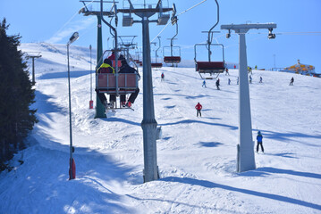 Fototapeta na wymiar Slope-Side View - Elevated Shot of Skiers and Chairlifts in the Heart of the Winter Sports Action