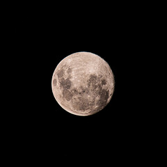 Fototapeta na wymiar Earth's moon at 98 percent full on a hot, dark and smoky night sky