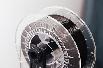 3d printing technology. 3d printing filament background.Black PLA wire in a roll. Home modern...