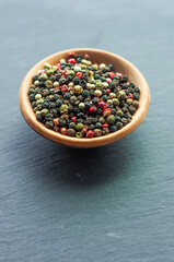 black red green white peppercorns, a mixture of peppers seasoning fragrant spice for fish meat close up on a black background