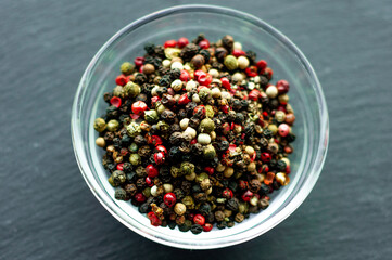 black red green white peppercorns, a mixture of peppers seasoning fragrant spice for fish meat close up on a black background