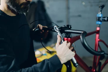 Keuken foto achterwand Motorfiets Mechanic repairman assembling bicycle handlebar custom bicycle in workshop