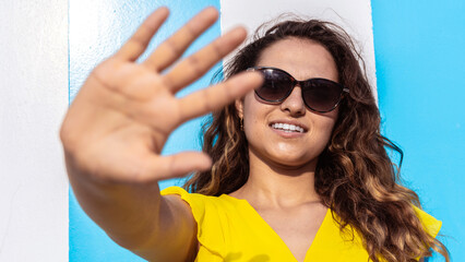 Young woman with yellow dress on stripes beach hut background