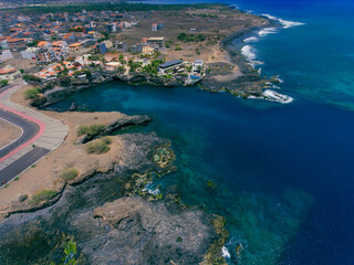Obraz premium Aerial photos of Tarrafal in Santiago Island, Cabo Verde showcase the stunning beaches and clear waters of this idyllic coastal town, as well as its colorful buildings, charming streets