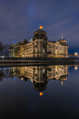 Fototapeta na wymiar Reichstag at night. Illuminated government building in Berlin. Government district in the center of the capital of Germany. River Spree with reflection on the water surface