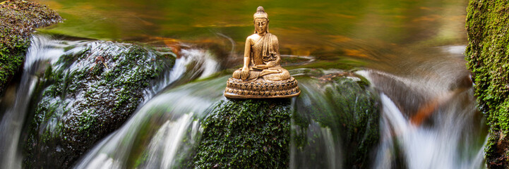   Buddha sculpture sitting in flowing water cascade