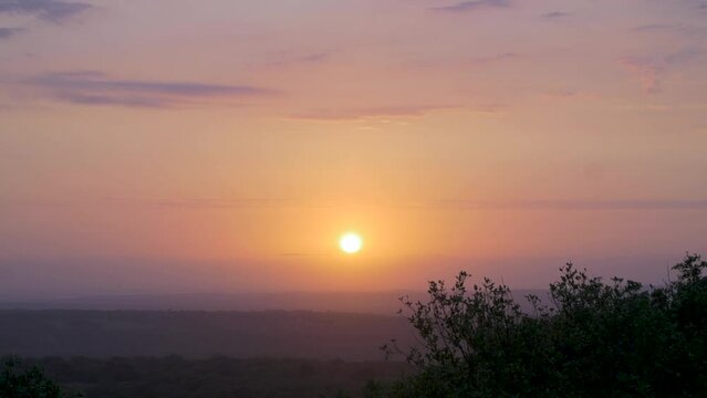 General shot of the African sun through the clouds at sunset.