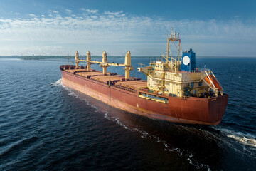 Large empty cargo ship in the sea during sunny summer day