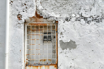 White uneven concrete wall with rustic steel door. White minialism